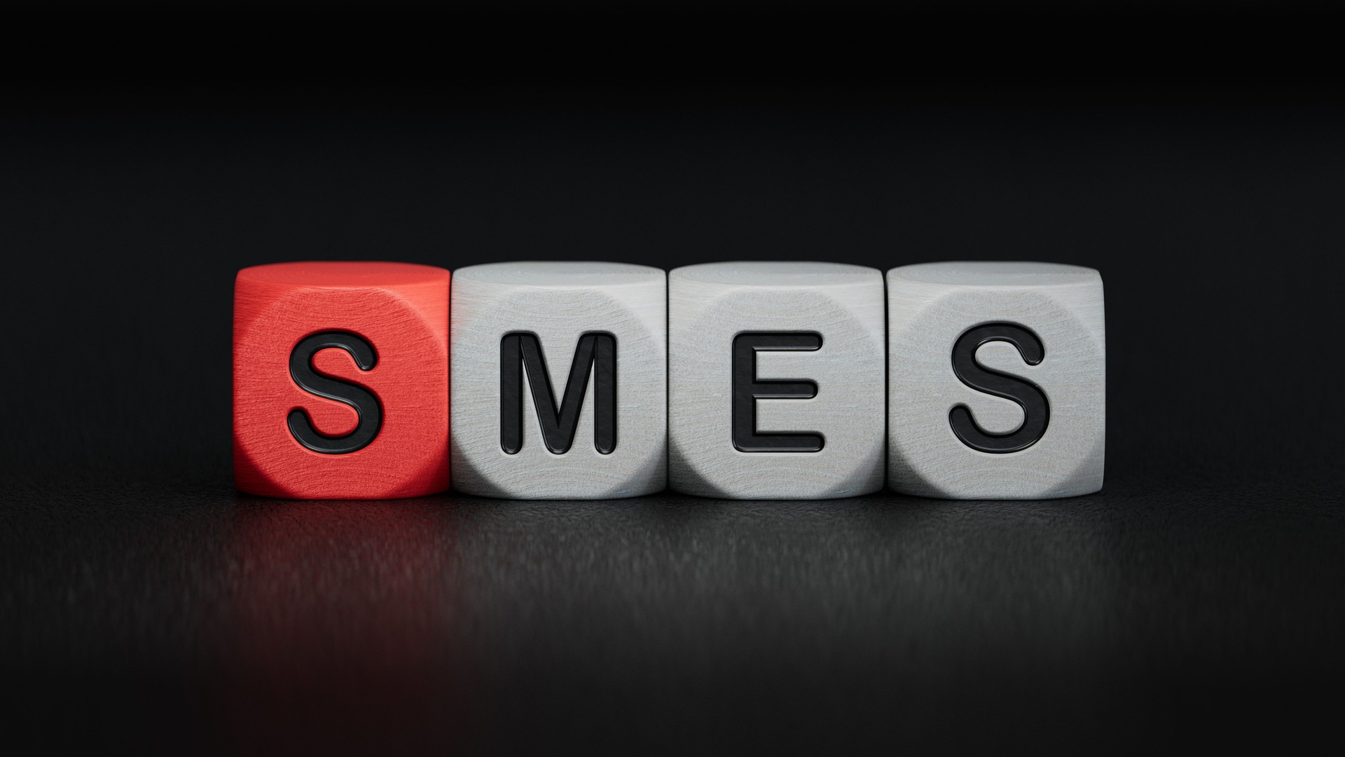 Small and medium-sized enterprises Word Written In Wooden Cubes.close up of wooden elements,Business Concept.3D rendering on black background.